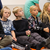 Børn sidder på gulvet og lytter